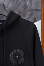 Black long zip hoodie side view with circular embroidered emblem on chest