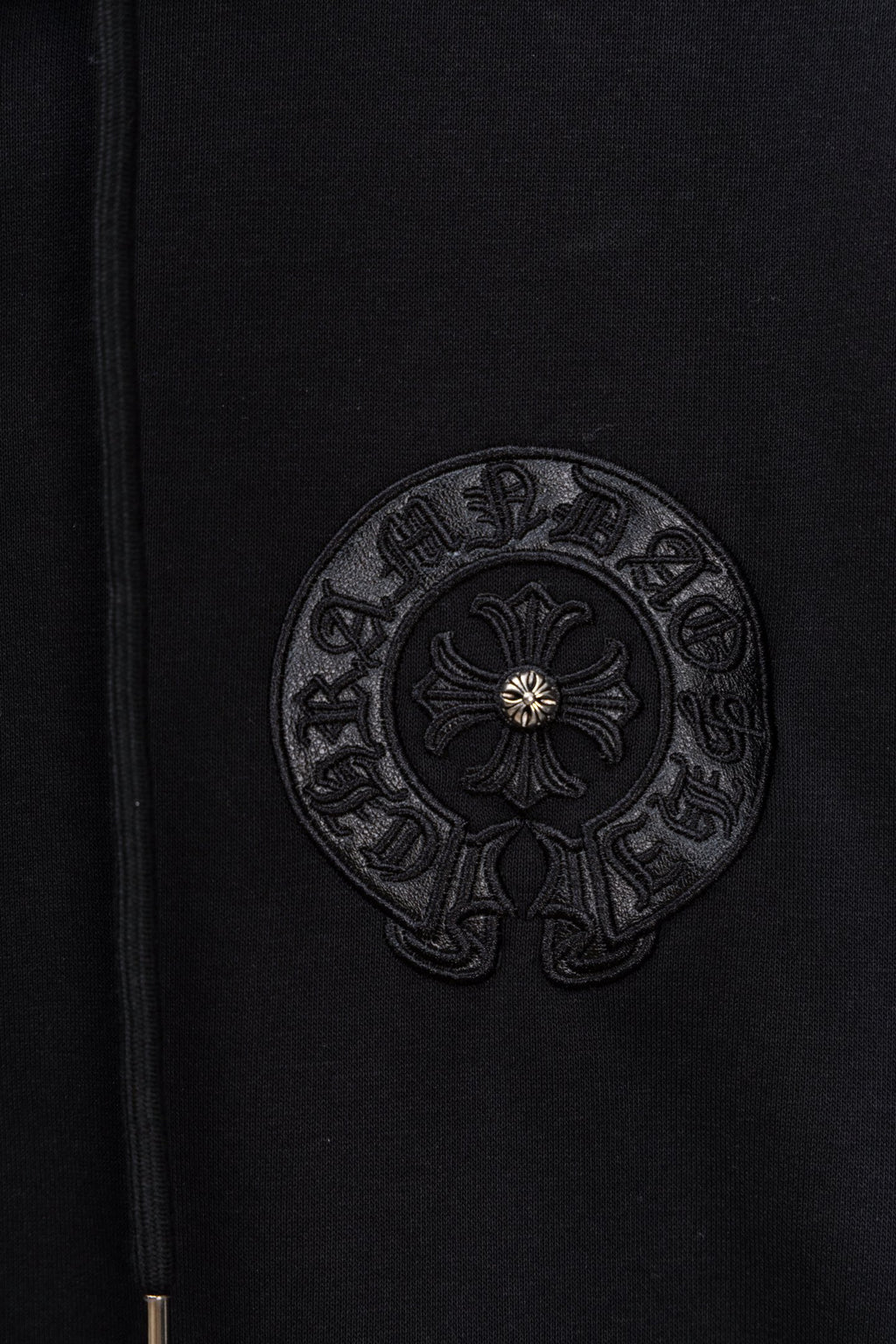 Black hoodie fabric with circular embroidered emblem patch