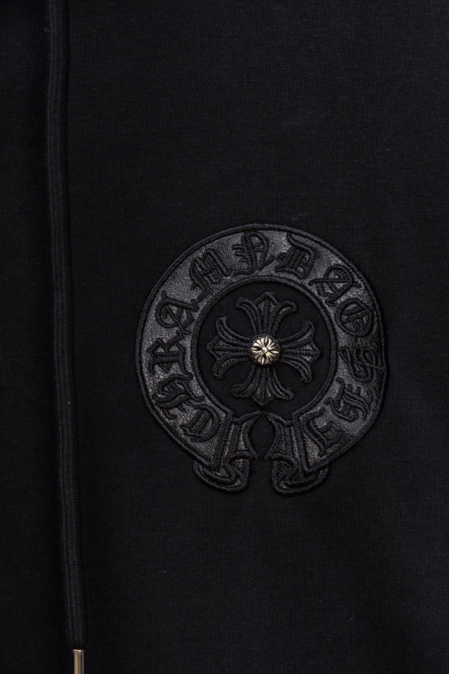 Black hoodie fabric with circular embroidered emblem patch