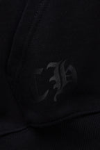 Black hoodie fabric with faint dark emblem detail