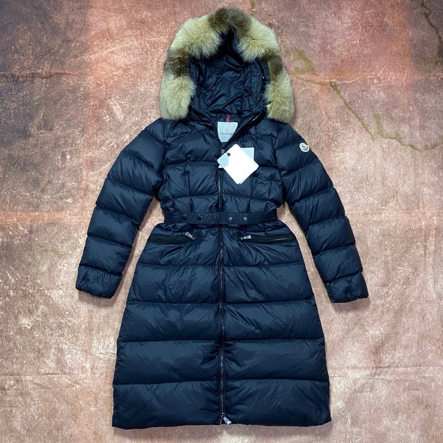 Moncler long puffer coat with green faux-fur hood, dark navy belted zip front