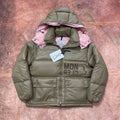 Olive green long puffer jacket with pink hood lining, quilted front and snap pockets.