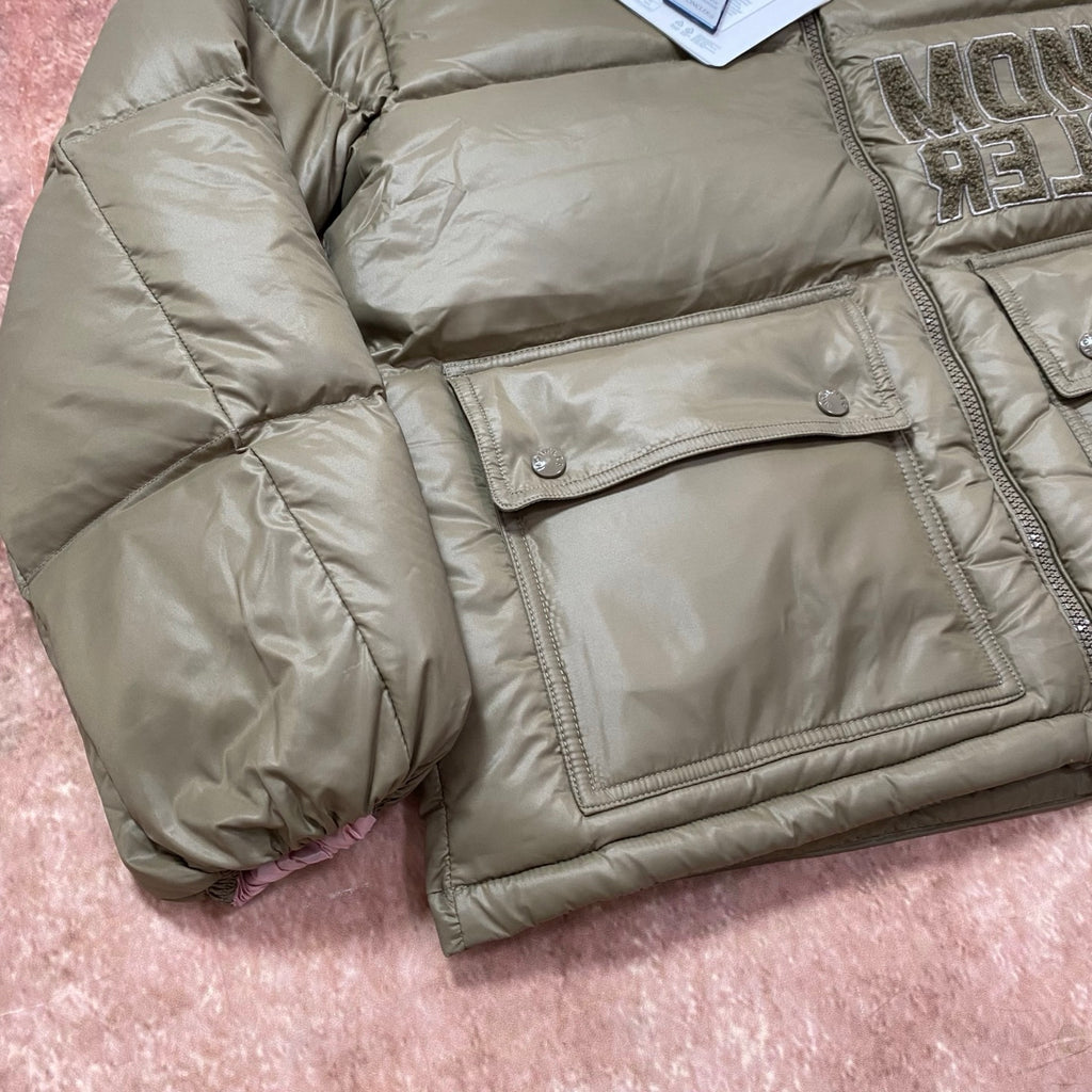 Olive green puffer jacket with flap chest pocket, quilted fabric and snap buttons.