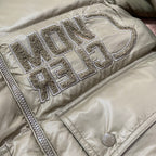 Olive green puffer jacket with raised metallic logo lettering on chest panel.