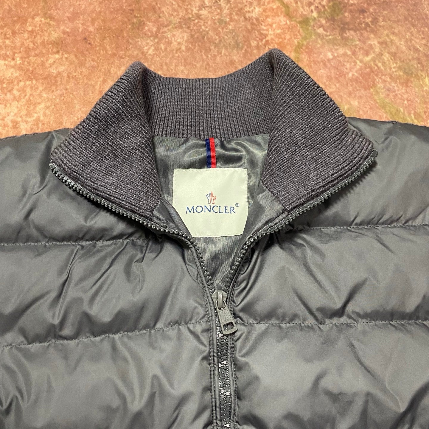 Long puffer jacket collar close-up with zipper and Moncler logo label