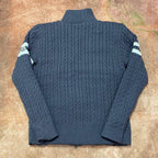 Long puffer jacket back view with ribbed knit sleeves and striped cuff details