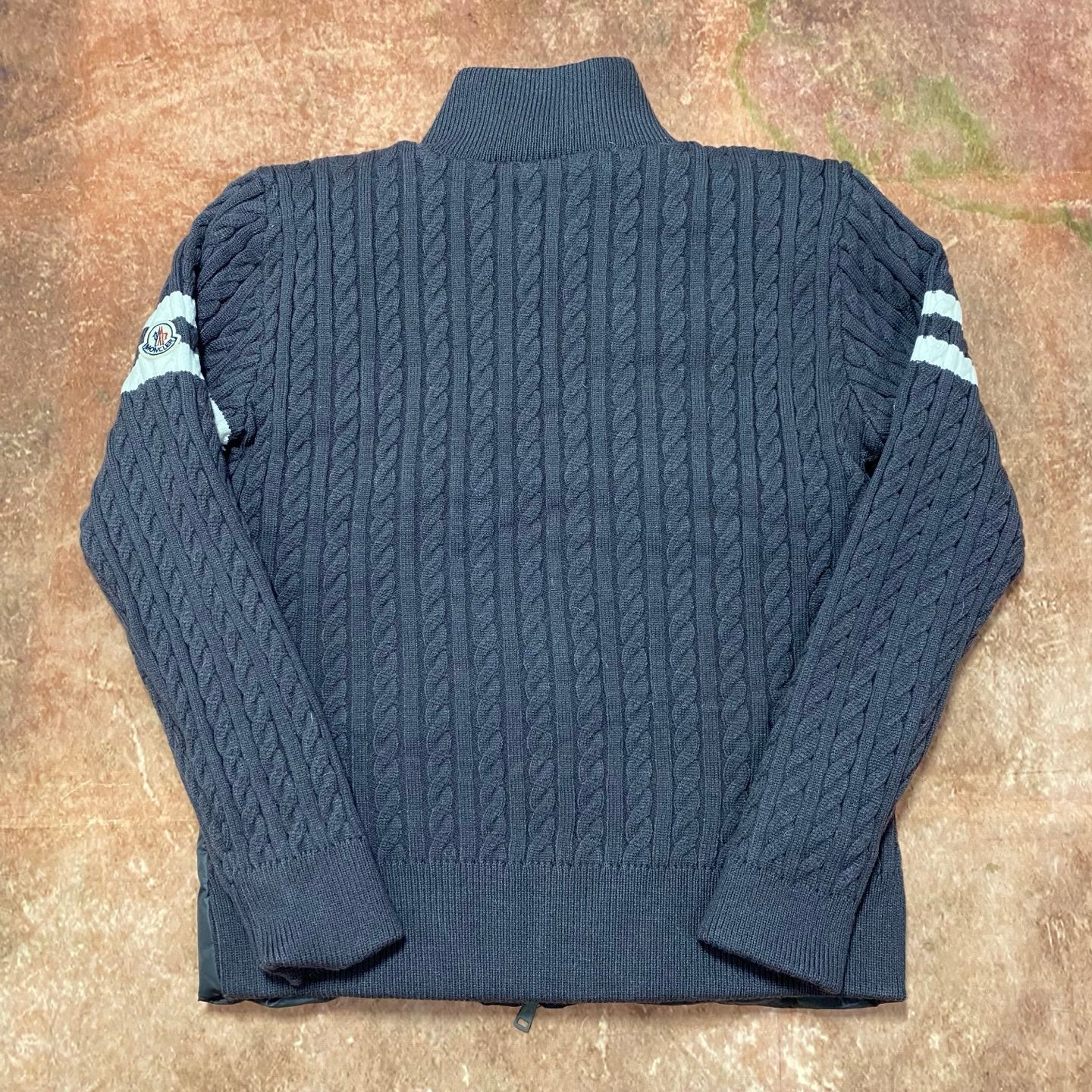 Long puffer jacket back view with ribbed knit sleeves and striped cuff details
