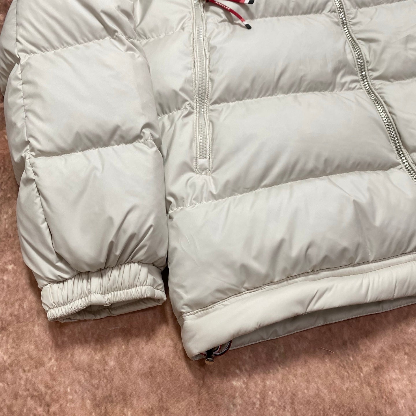 Moncler cream puffer jacket lower body with quilted panels and ribbed elastic cuffs