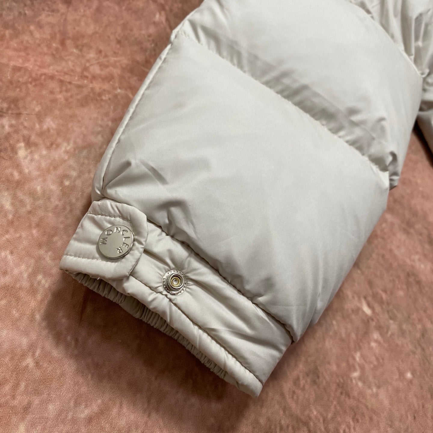 Moncler cream puffer jacket sleeve cuff with snap button and textured hem stitching