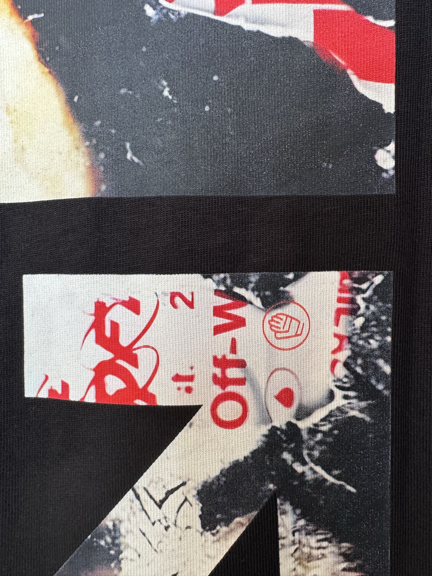 Black T-shirt fabric close-up with red Off-White™ text and circular logo
