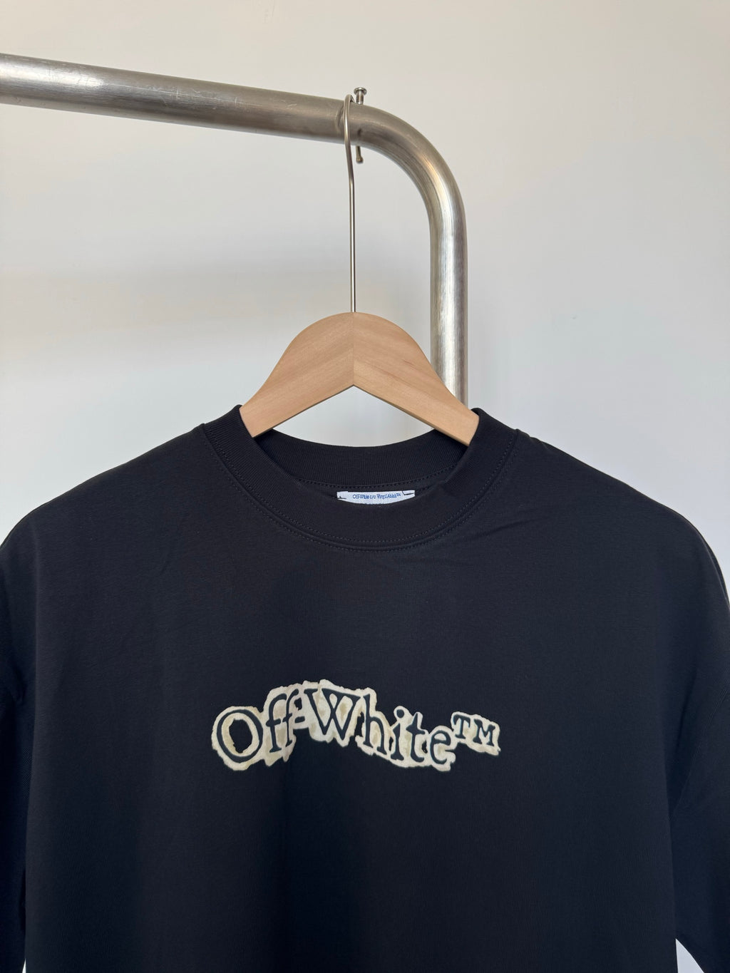 Dark crewneck T-shirt front with Off-White logo print, close view
