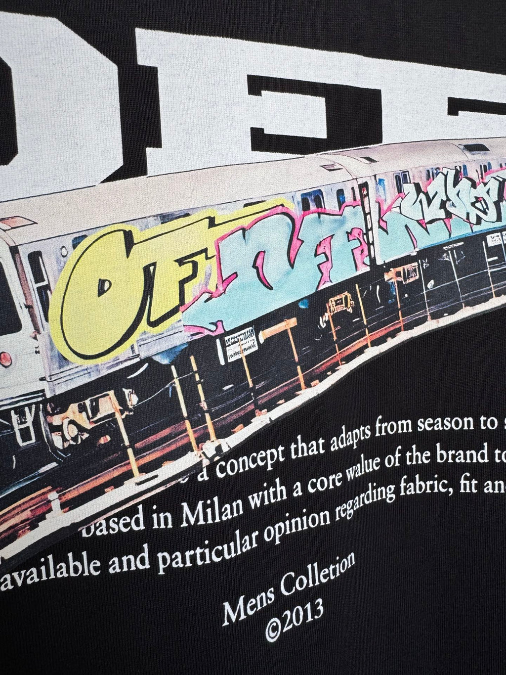 Off White T-shirt close-up of graffiti train graphic and white slogan text