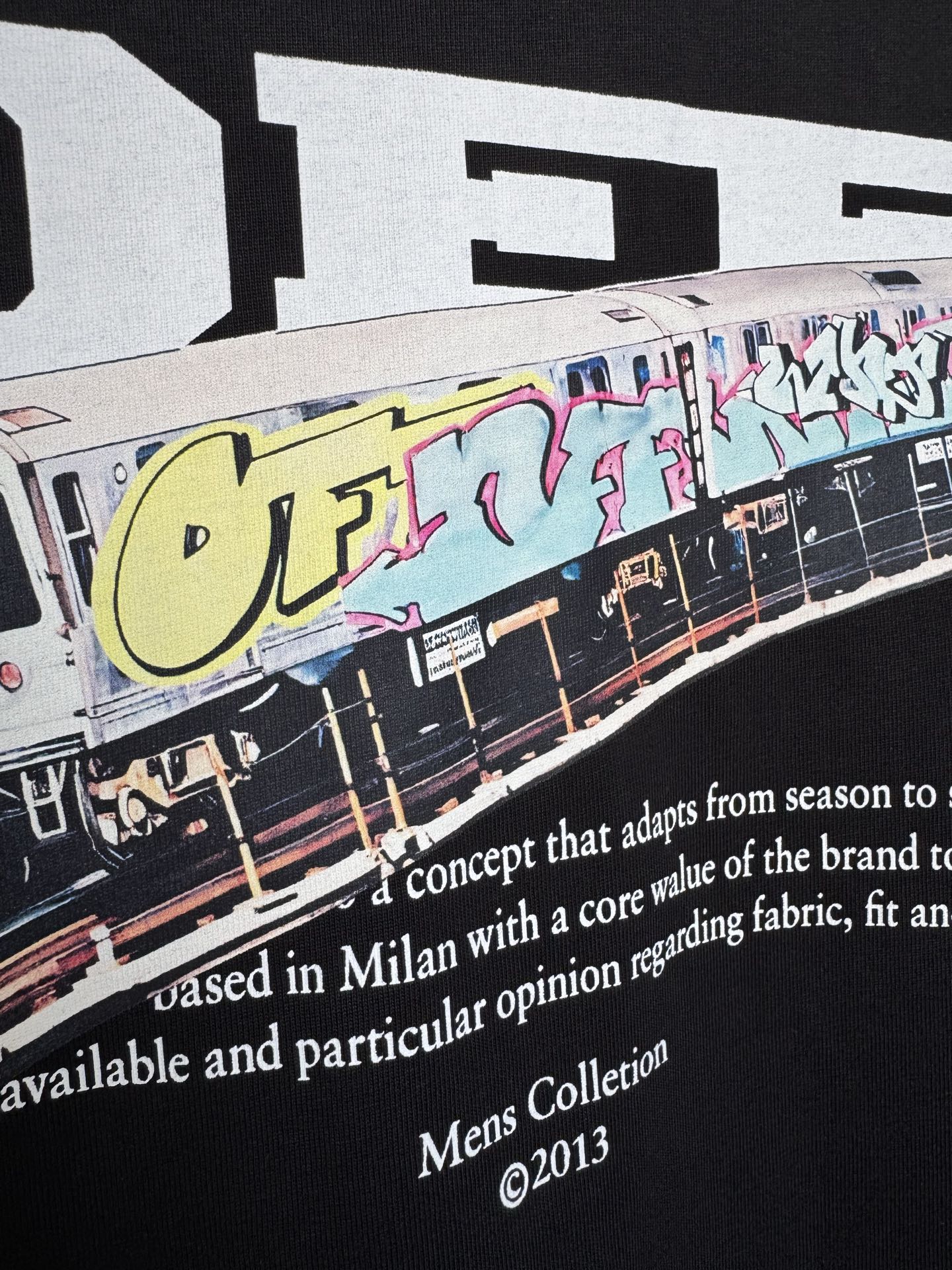 Off White T-shirt close-up of graffiti train graphic and white slogan text