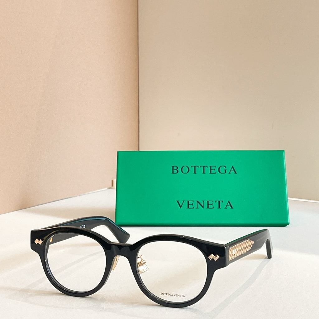 Eyeglasses with dark frames and gold patterned temple detail