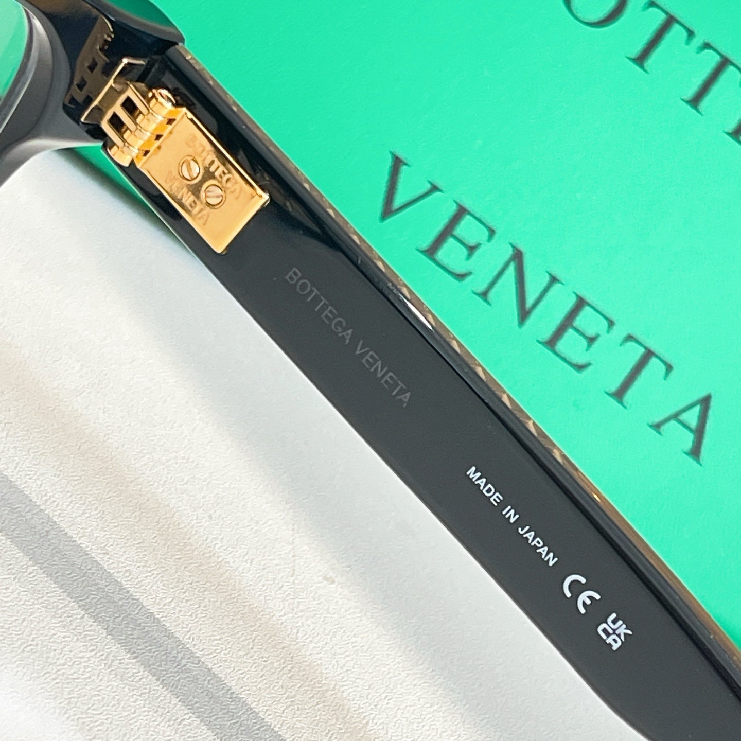 Eyeglasses temple close-up in black with gold plate and Made in Japan text