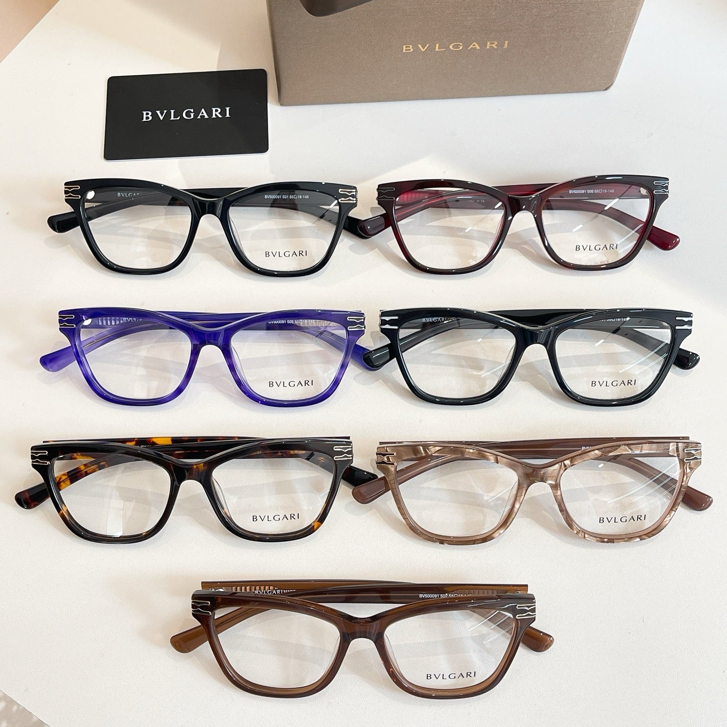 Multi-color eyeglass frames set in black, red, blue, and brown with BVLGARI logos.