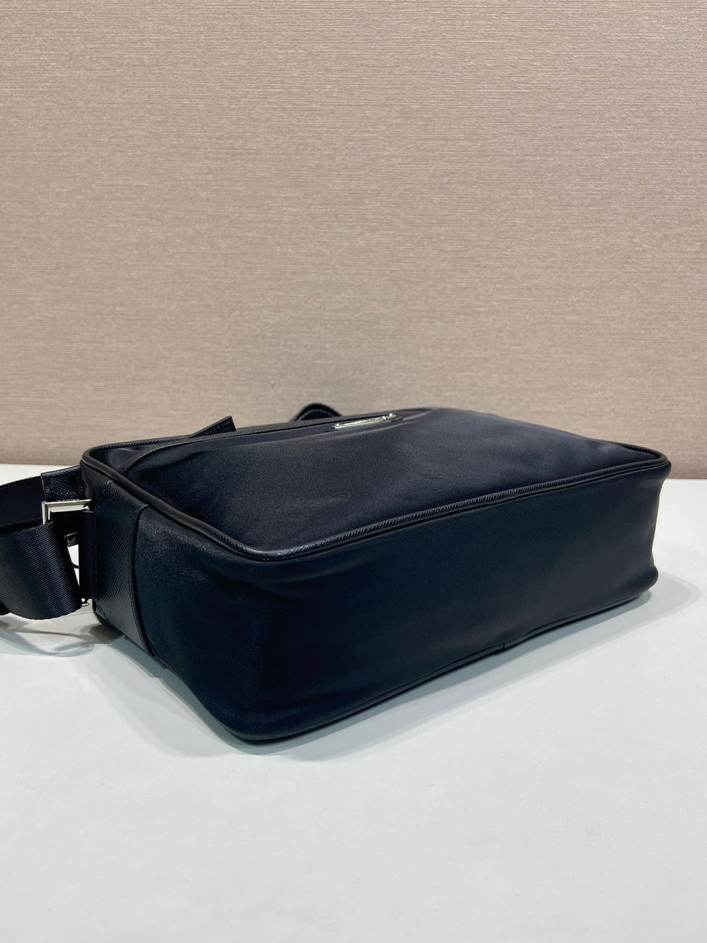 Dark blue crossbody bag with structured shape and side zipper closure
