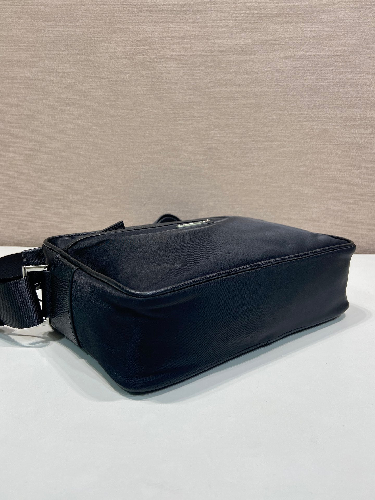 Dark blue crossbody bag with structured shape and side zipper closure