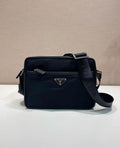 Dark blue shoulder bag with logo plaque, front zip pocket, and crossbody strap