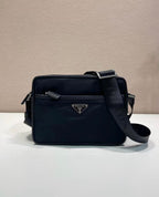 Dark blue shoulder bag with logo plaque, front zip pocket, and crossbody strap