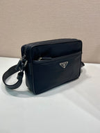 Dark blue shoulder bag with logo plaque, front pocket, and side zip details
