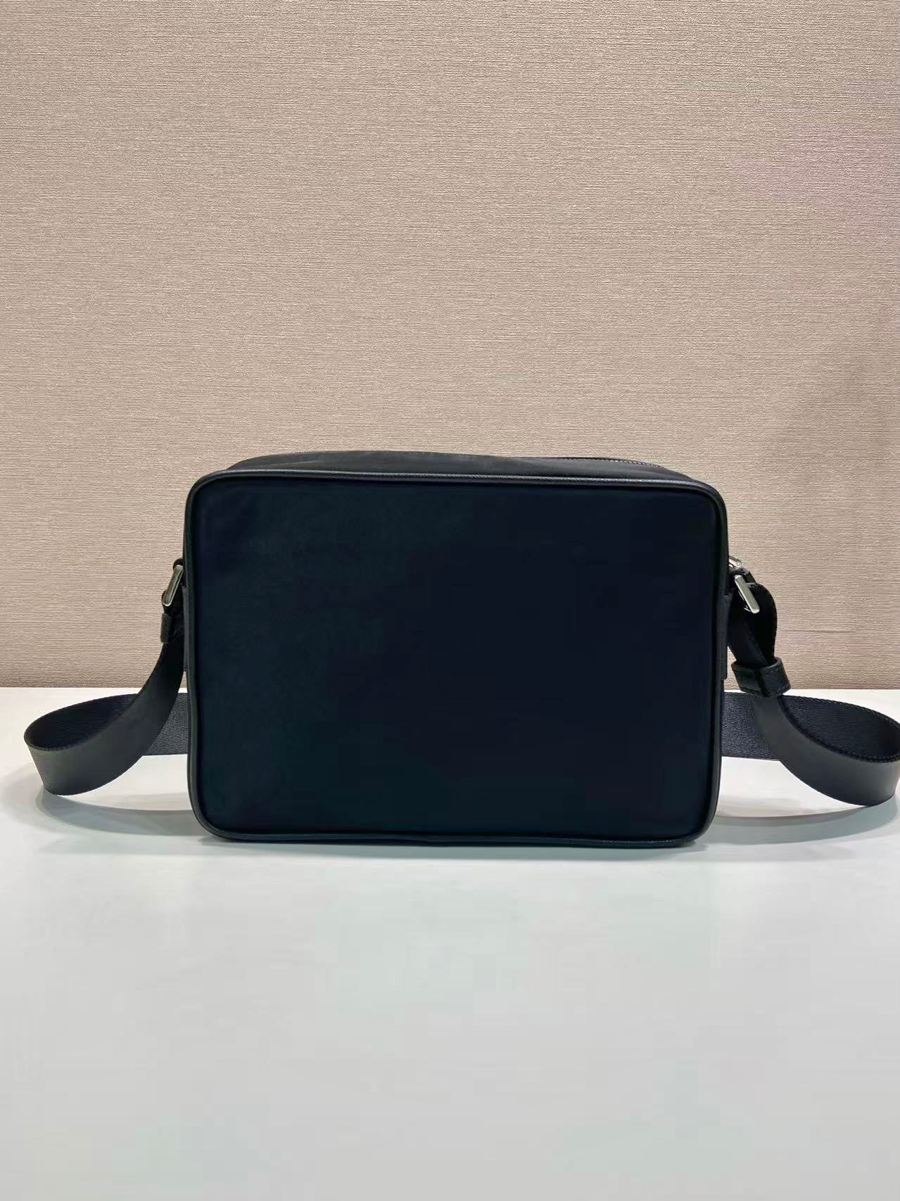 Dark blue rectangular shoulder bag with top handle and side crossbody straps
