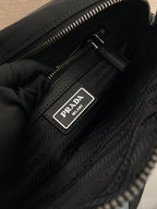 Black lining with Prada logo patch and zipper track inside the bag