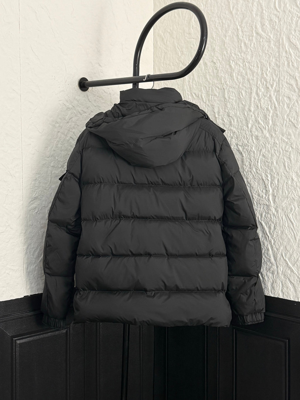 Long black puffer jacket with hood and back yoke seams