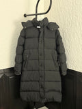 Long puffer coat with hood, dark fabric, button front and side pockets.
