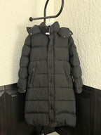 Long puffer coat with hood, dark fabric, button front and side pockets.