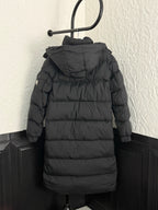 Back view long puffer coat with hood, dark fabric, quilted horizontal panels.