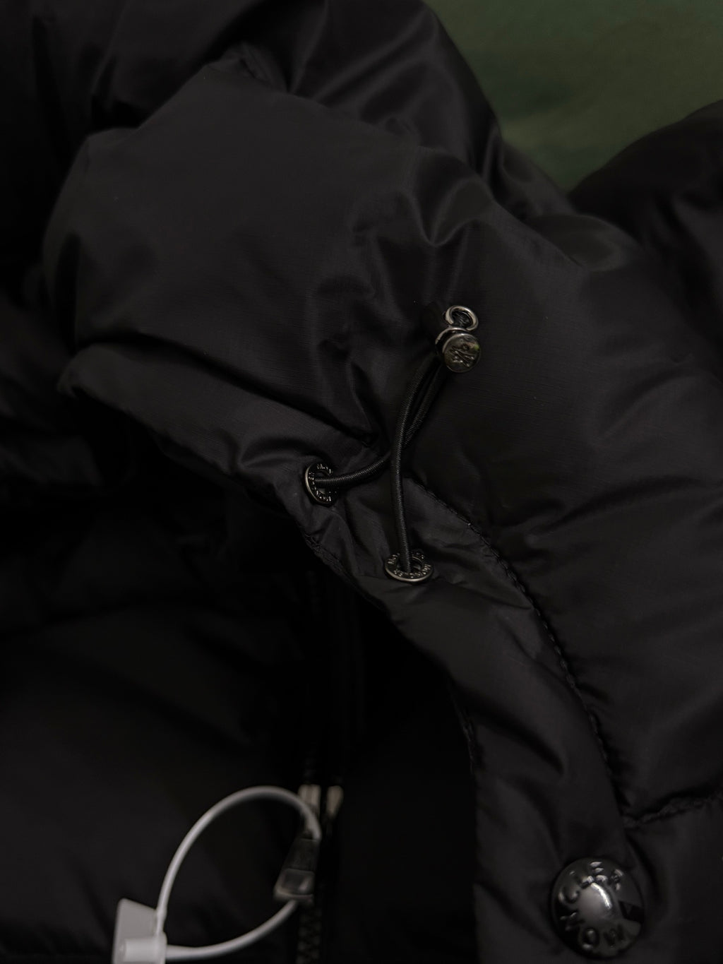 Black puffer jacket hood drawstring with metal toggles