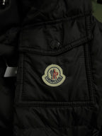 Black puffer jacket chest pocket with Moncler crest patch