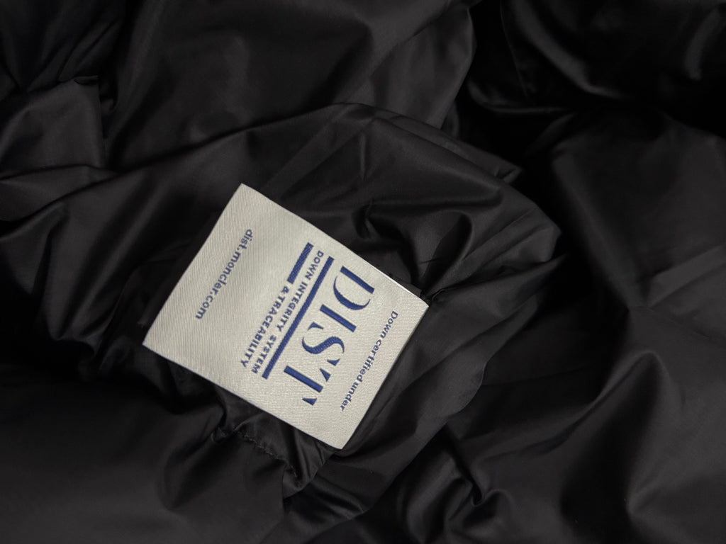 White Moncler-style care label on black puffer jacket lining
