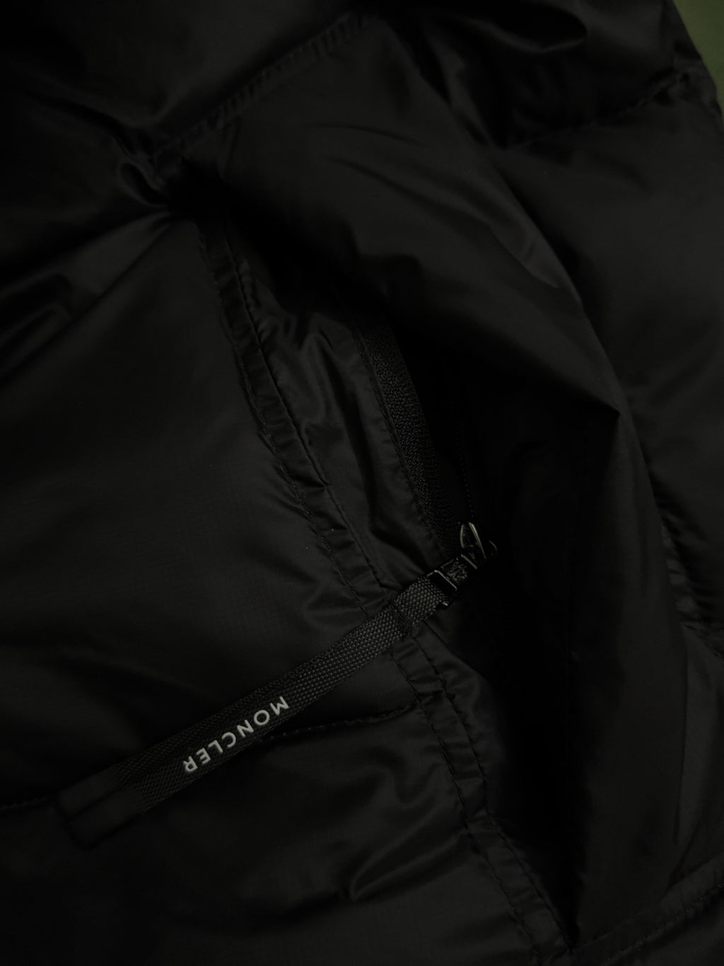 Black puffer jacket fabric with zipper seam detail