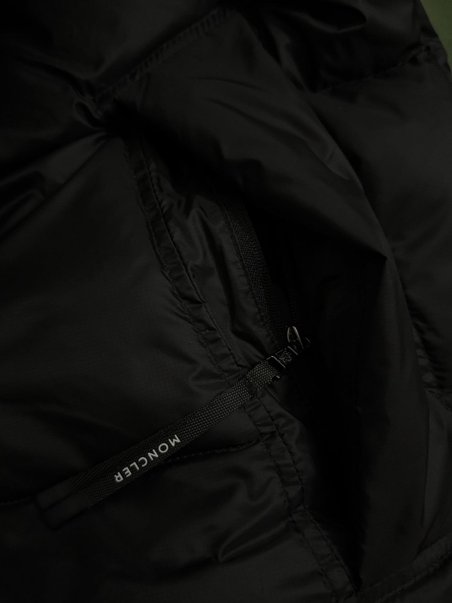 Black puffer jacket fabric with zipper seam detail