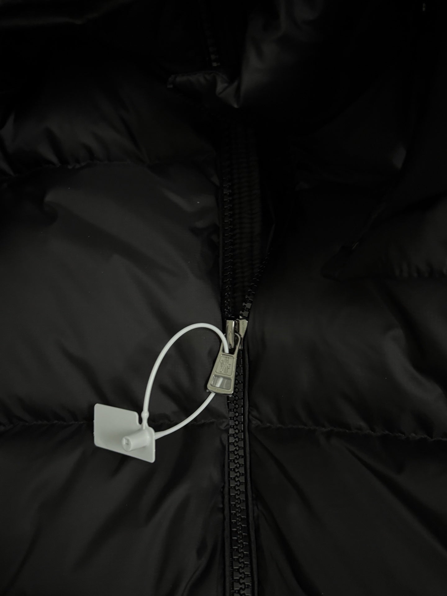 Black puffer jacket zipper with fabric tab and pull loop
