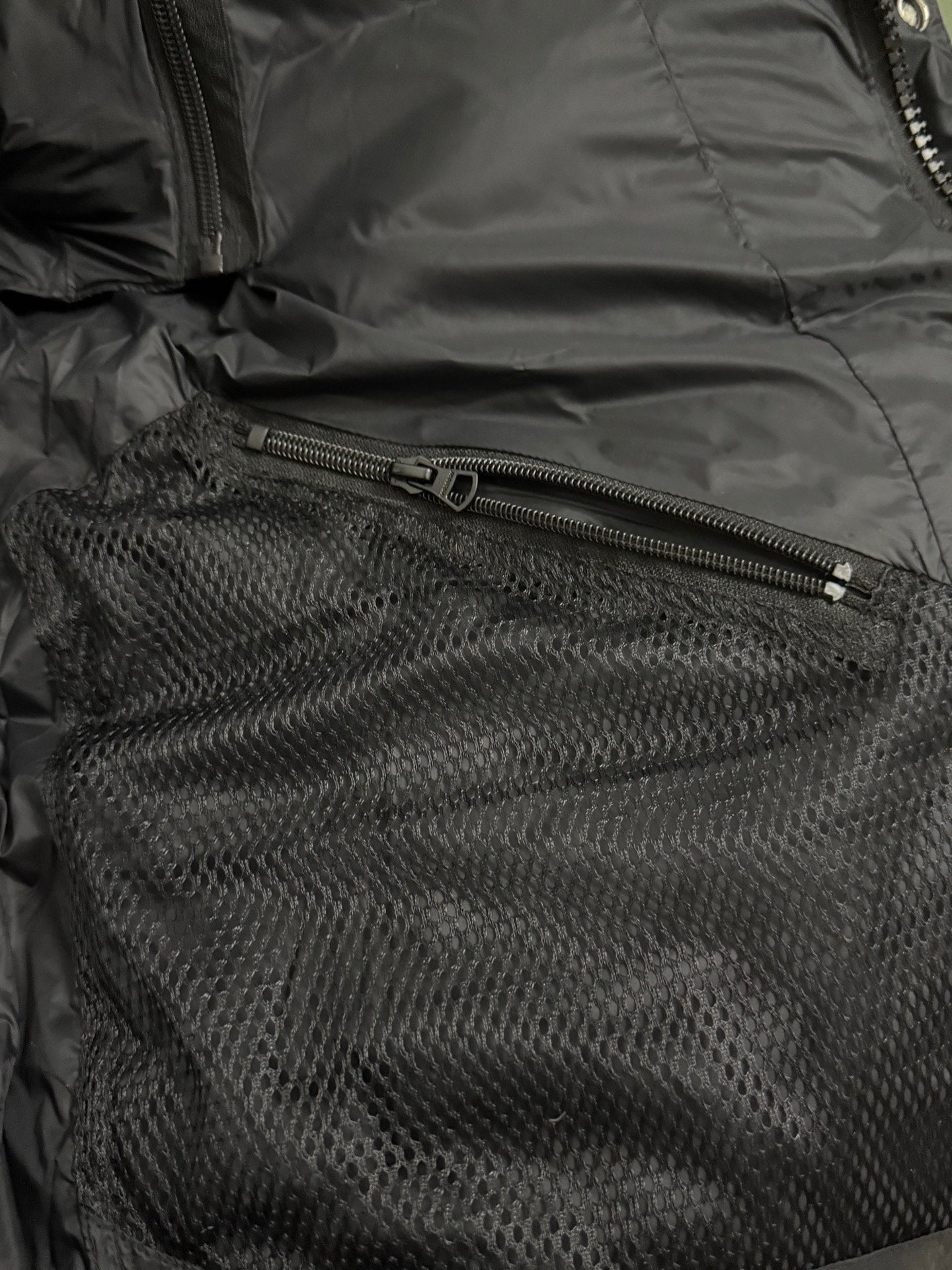 Black puffer interior with mesh pocket and zipper closure