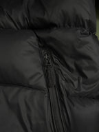 Black padded jacket front with full zipper and stitched fabric panels