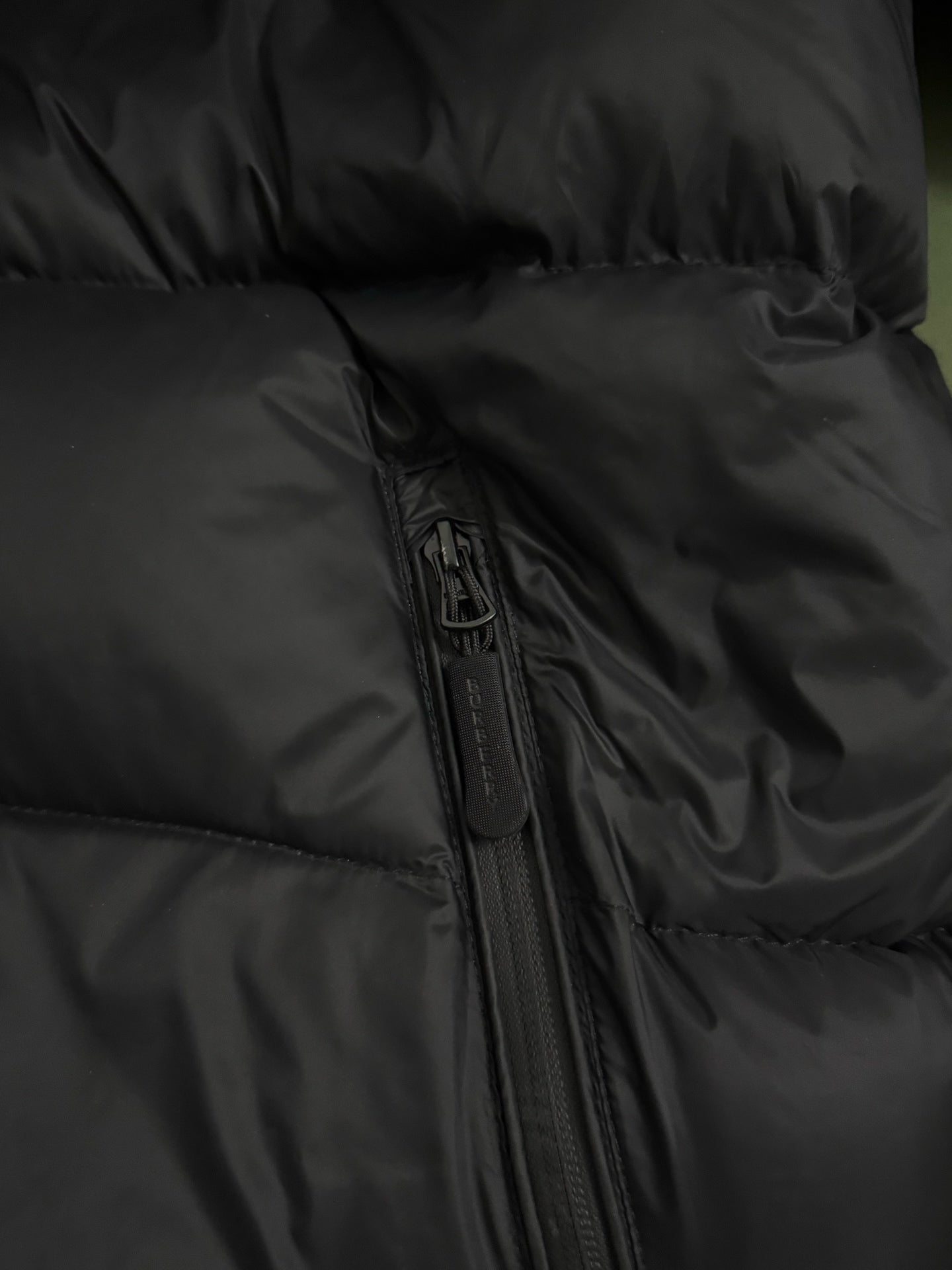 Black padded jacket front with full zipper and stitched fabric panels