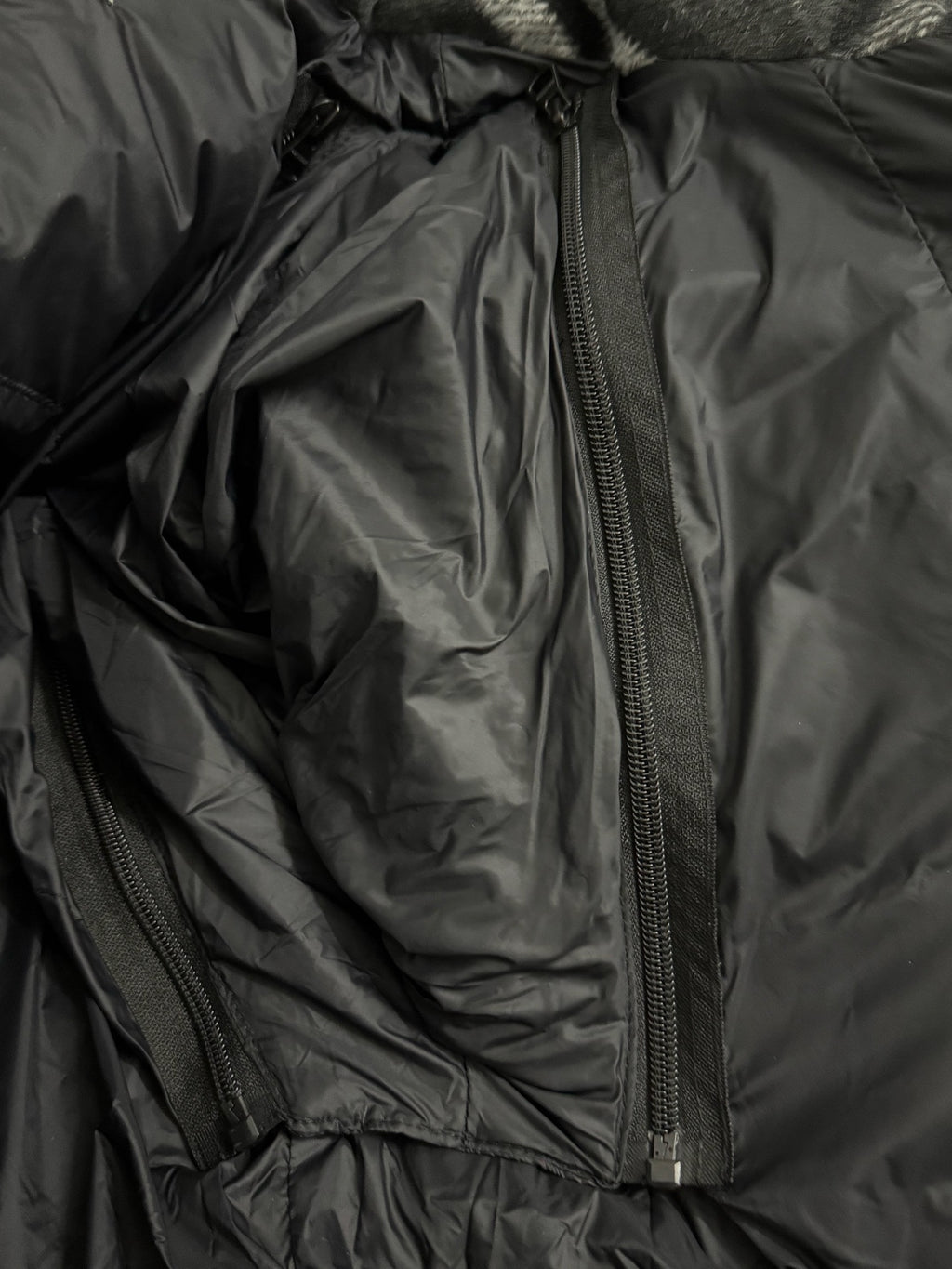 Black puffer jacket interior with long zipper and padded lining