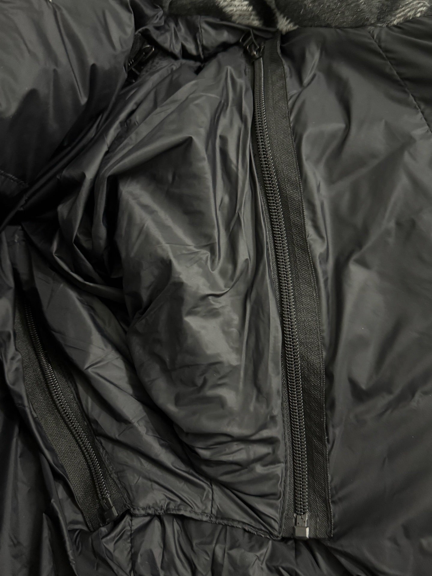 Black puffer jacket interior with long zipper and padded lining