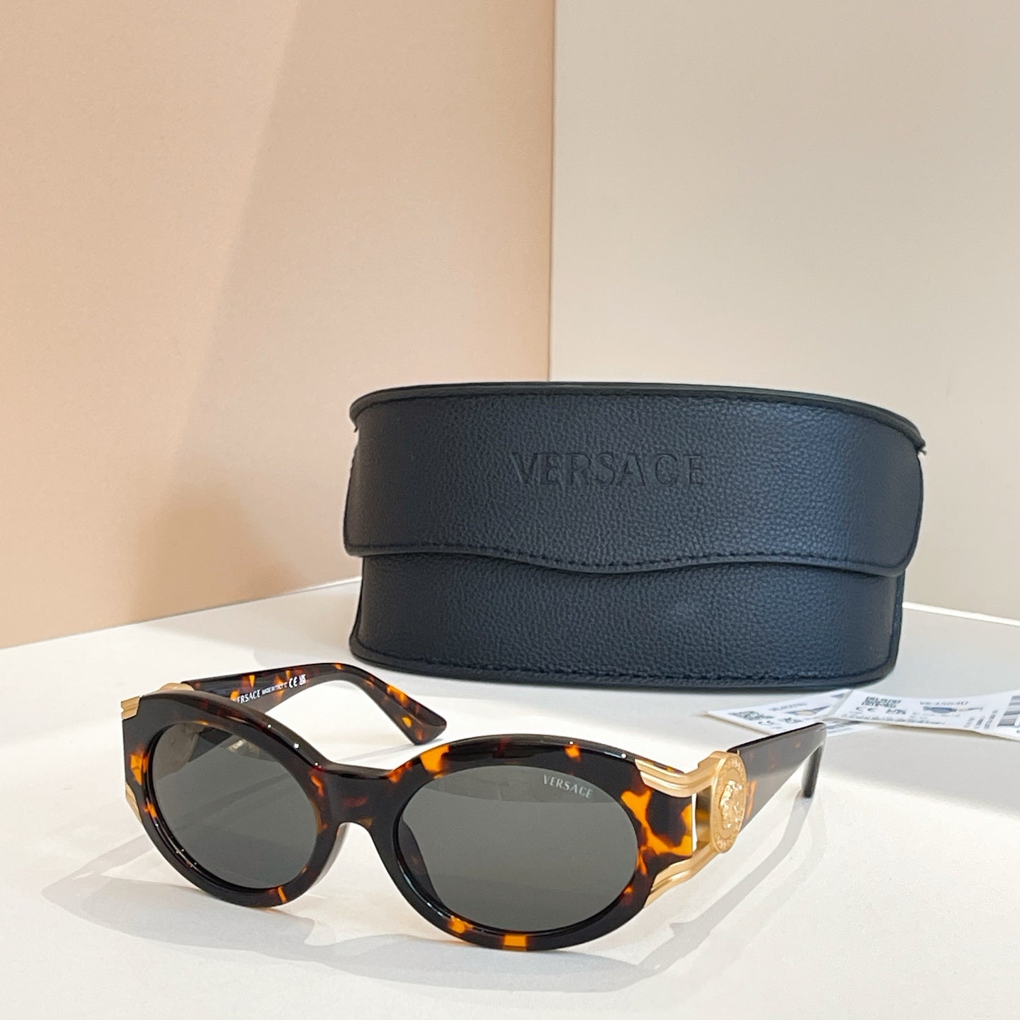 Versace round sunglasses with tortoiseshell frames and gray tinted lenses