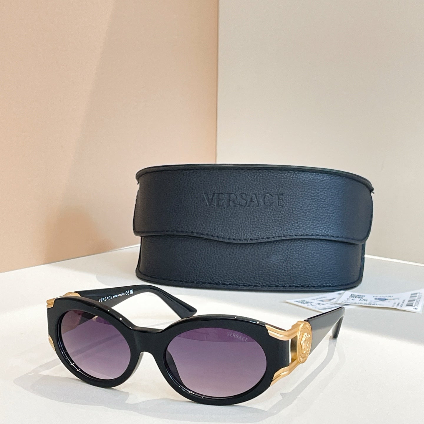 Versace round sunglasses with black frames and purple tinted lenses