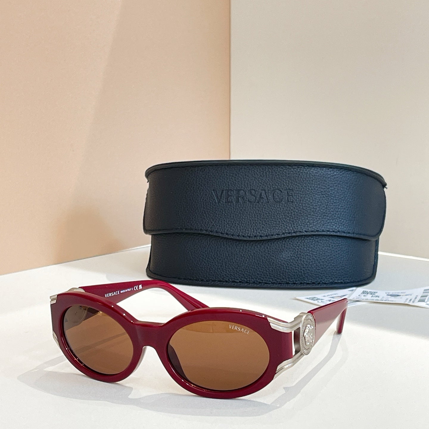 Versace round sunglasses with red frames and tinted brown lenses