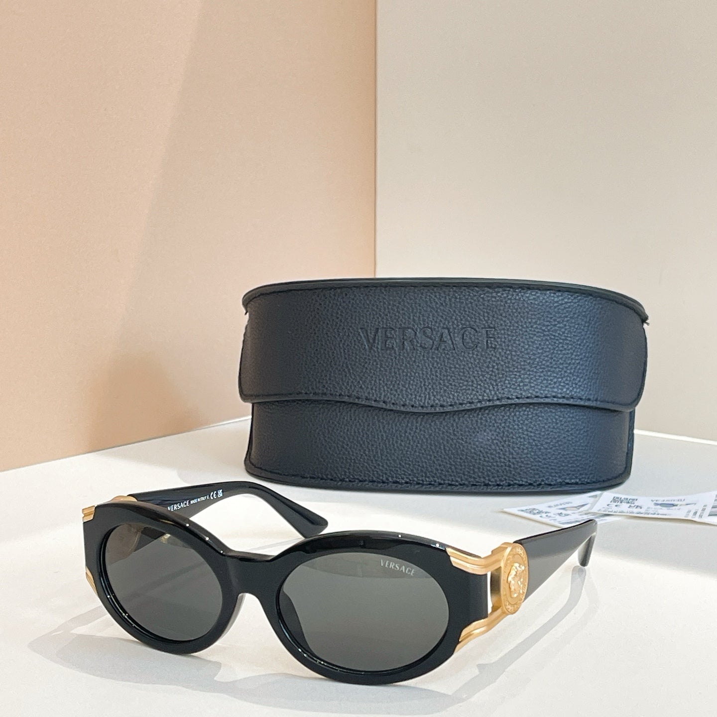 Versace round sunglasses with black frames and dark lenses with gold accents