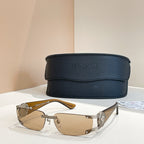 Brown-lens sunglasses with gold frame and silver arms, black case behind