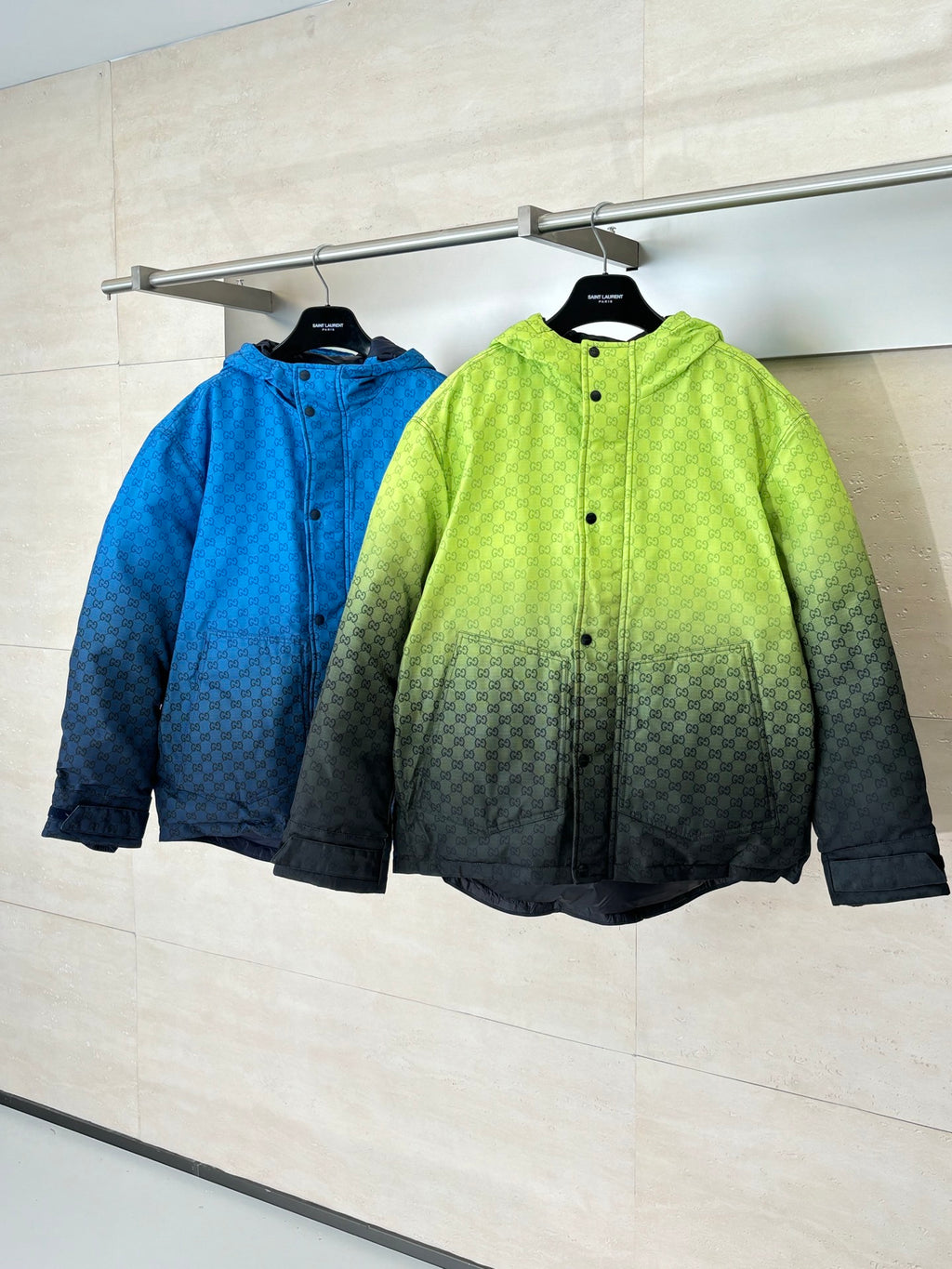 Lime green and blue hooded puffer jackets hanging together