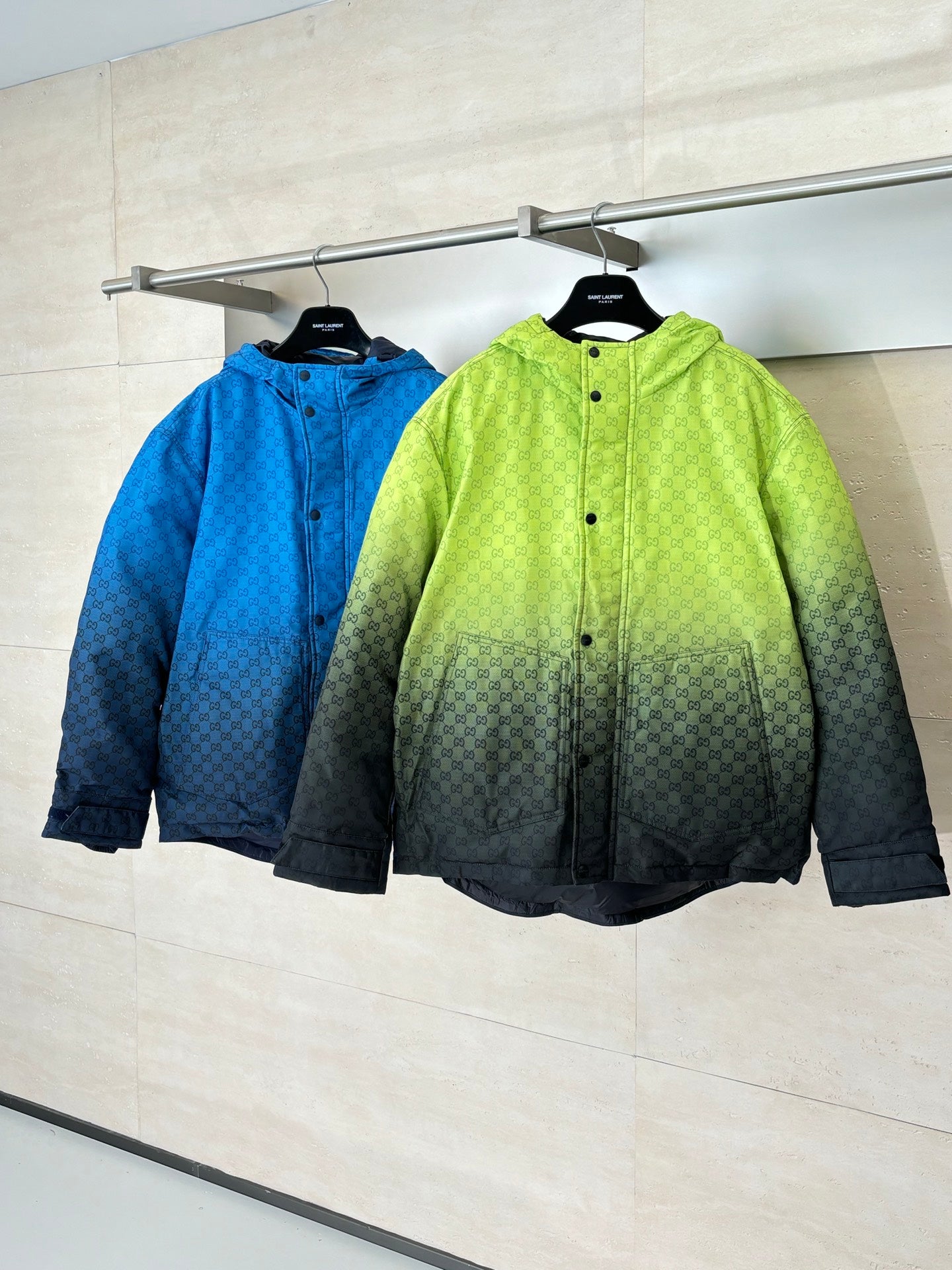 Lime green and blue hooded puffer jackets hanging together
