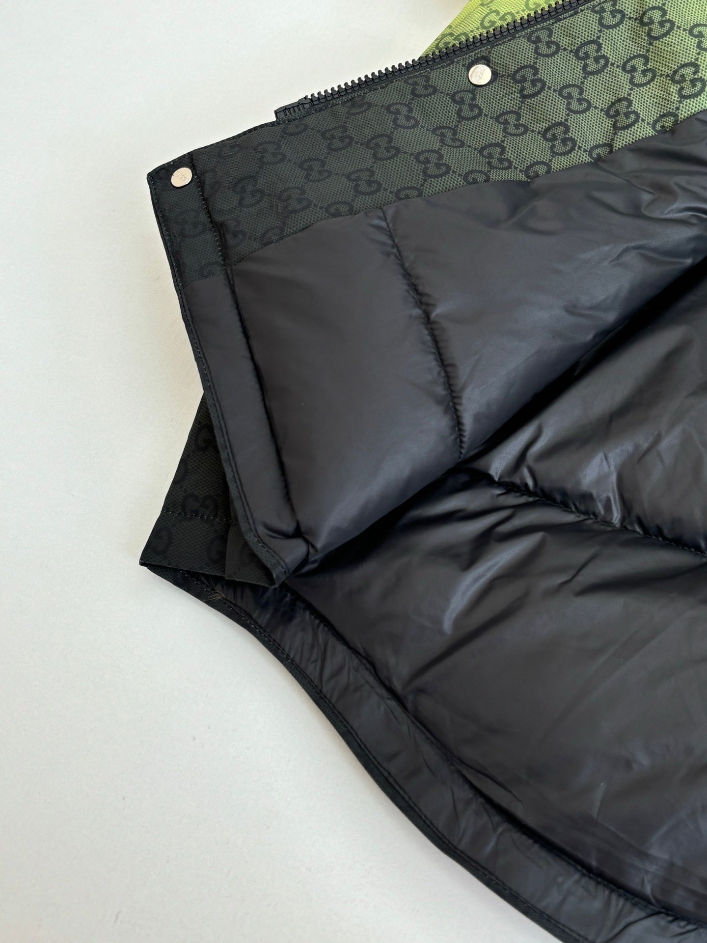 Black puffer jacket with GG-pattern upper panel and quilted seams